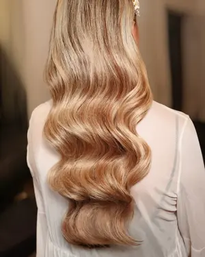 Long blonde hair in deep glossy waves, seen from behind