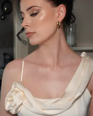 Sleek high bun with face-framing tendrils and glowing skin